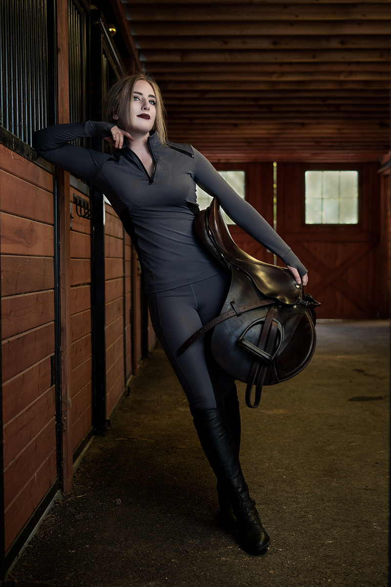 woman with saddle in barn