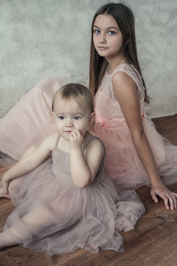two children wearing soft pink dresses