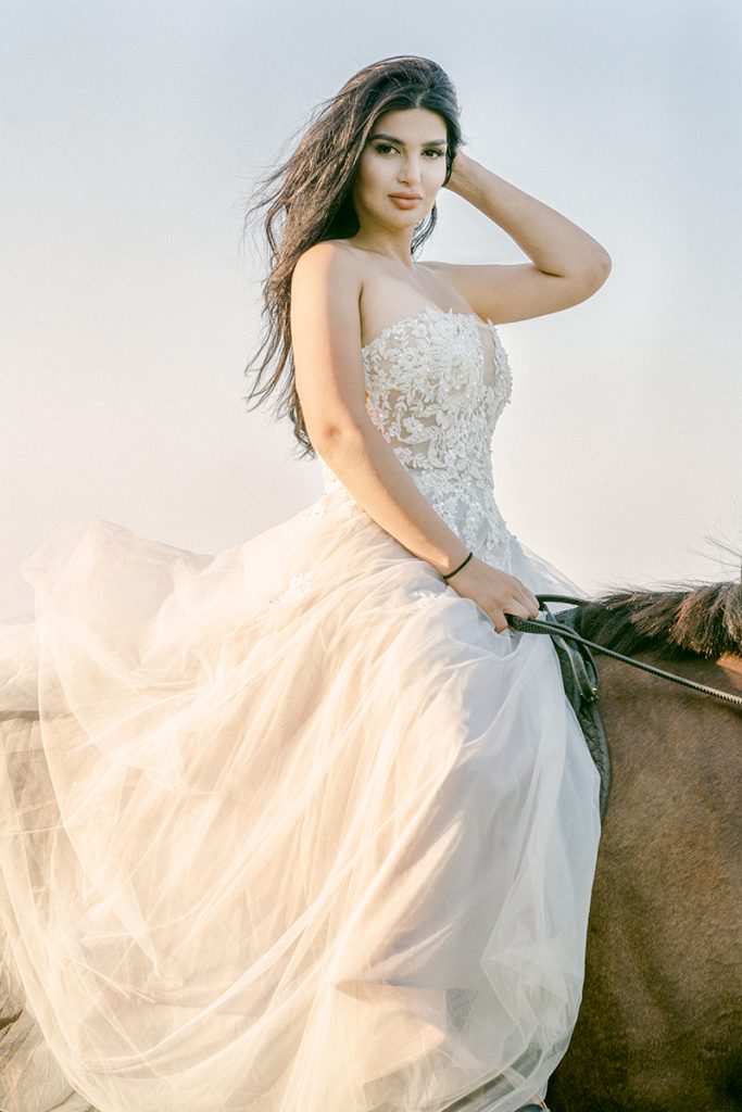 equestrian mounted on horse flowing white dress