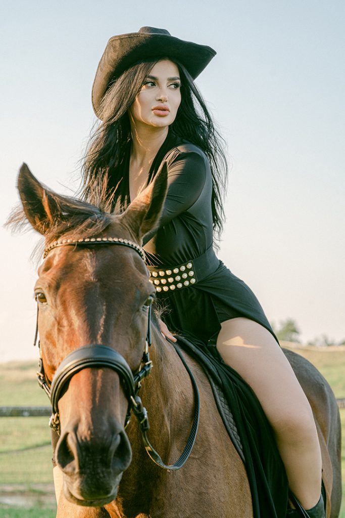 equestrian in western style clothing riding a horse