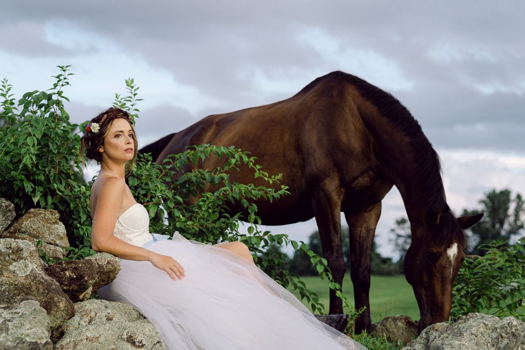 woman in wedding dress in front of horse