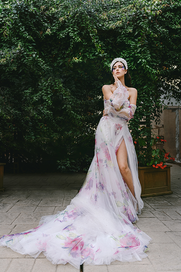 model wearing floral bridal dress in front of foliage