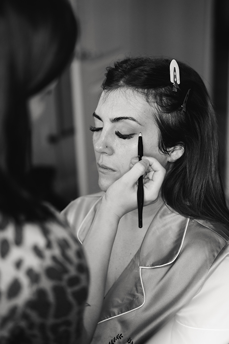 black and white image of bride getting makeup done