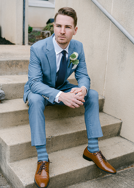 groom sitting on stairs
