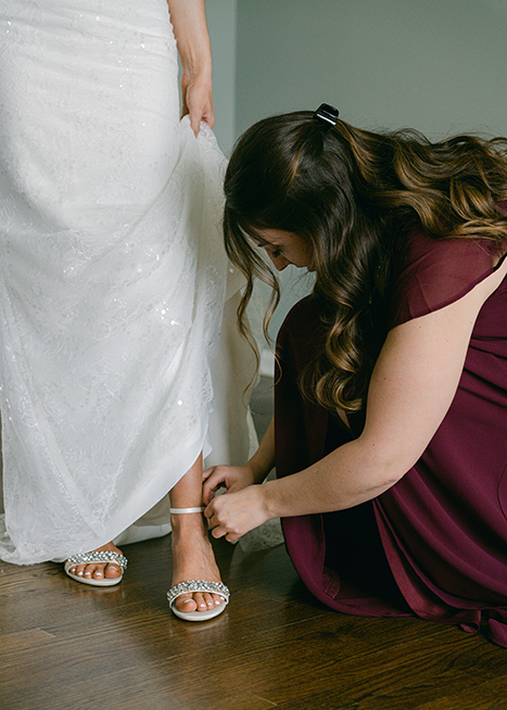 bride getting her shoes put on