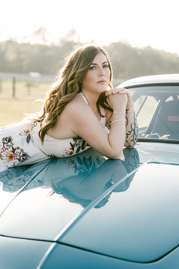 woman leaning against classic car