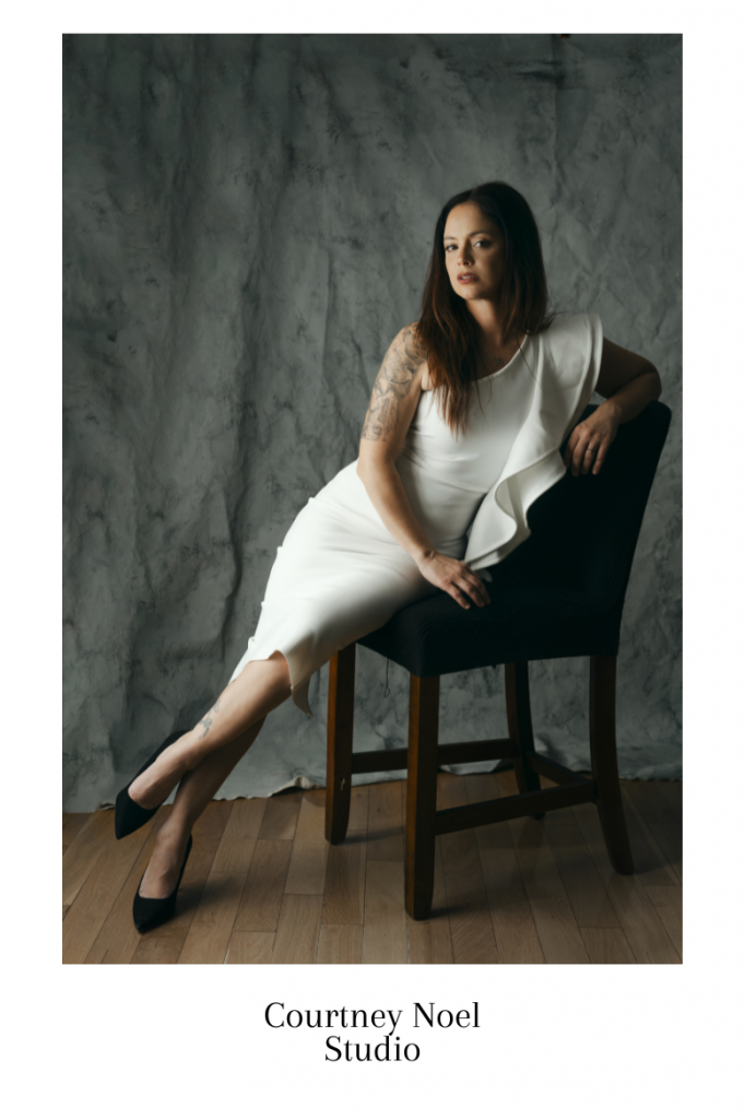 portrait of a woman wearing a white dress posing on a chair