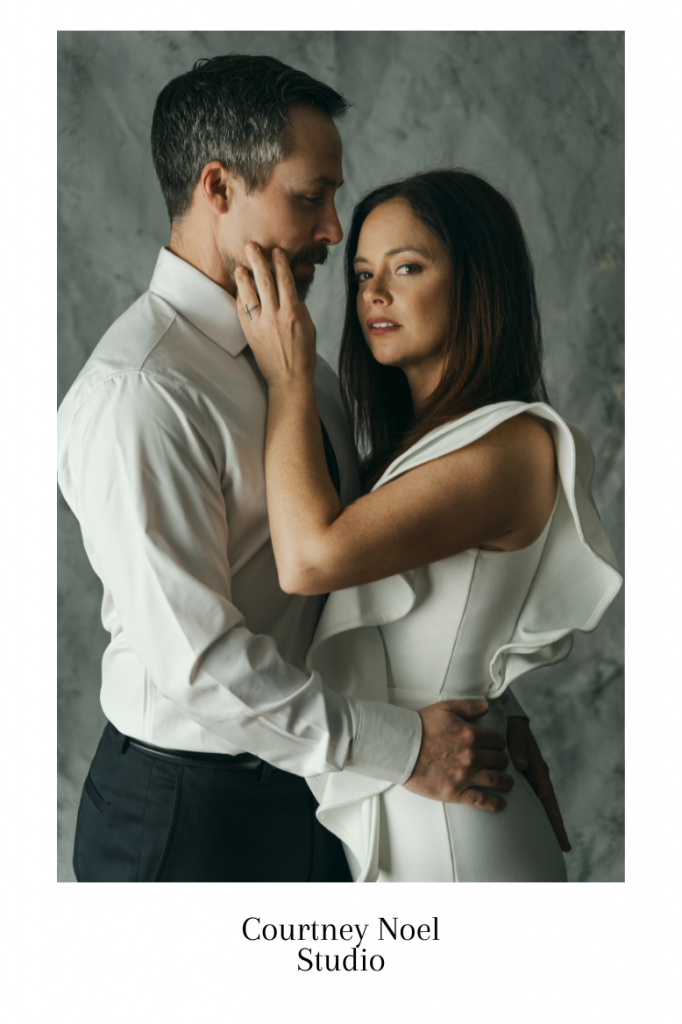 engaged couple posing wearing white